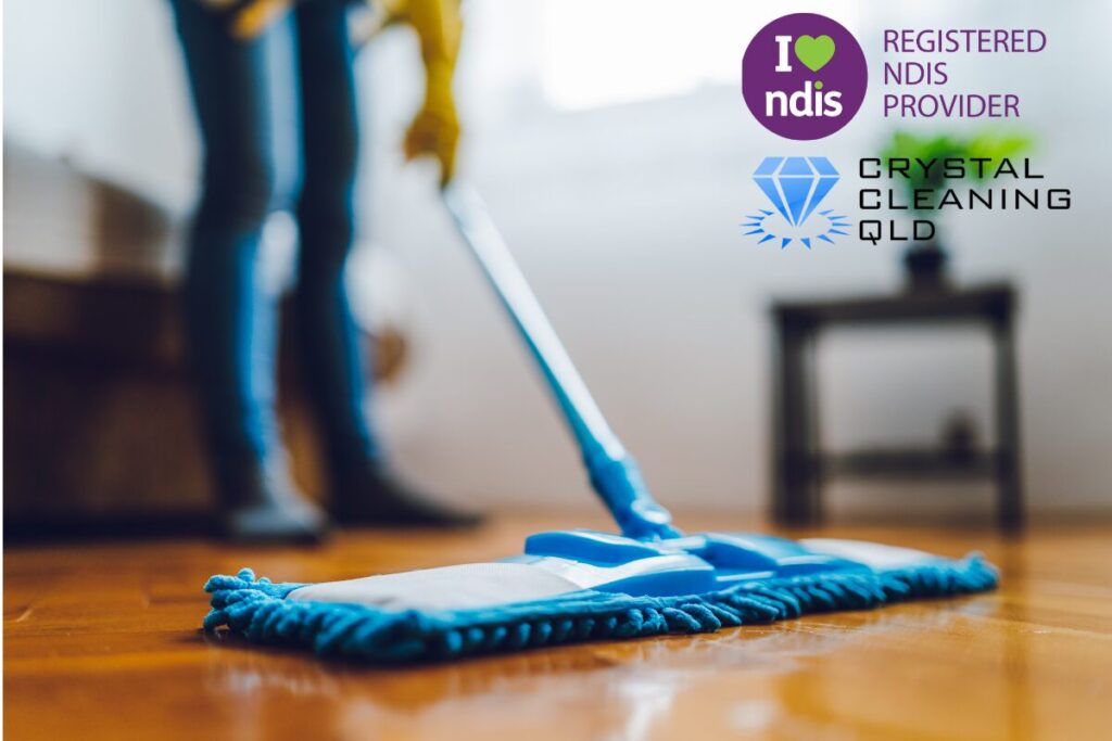 Professional cleaner mopping a hardwood floor during an NDIS House Cleaning Brisbane service by Crystal Cleaning QLD.